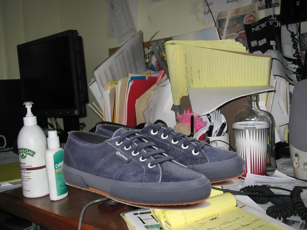 A sneaker on a cluttered desk